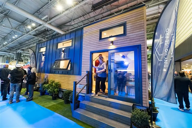A group of people standing in front of an exhibitor trailer.